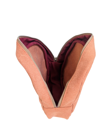 The inside of a peach pouch with a red zipper.
