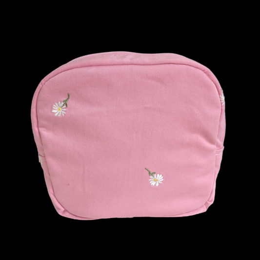 A pink pouch with daisies on it.