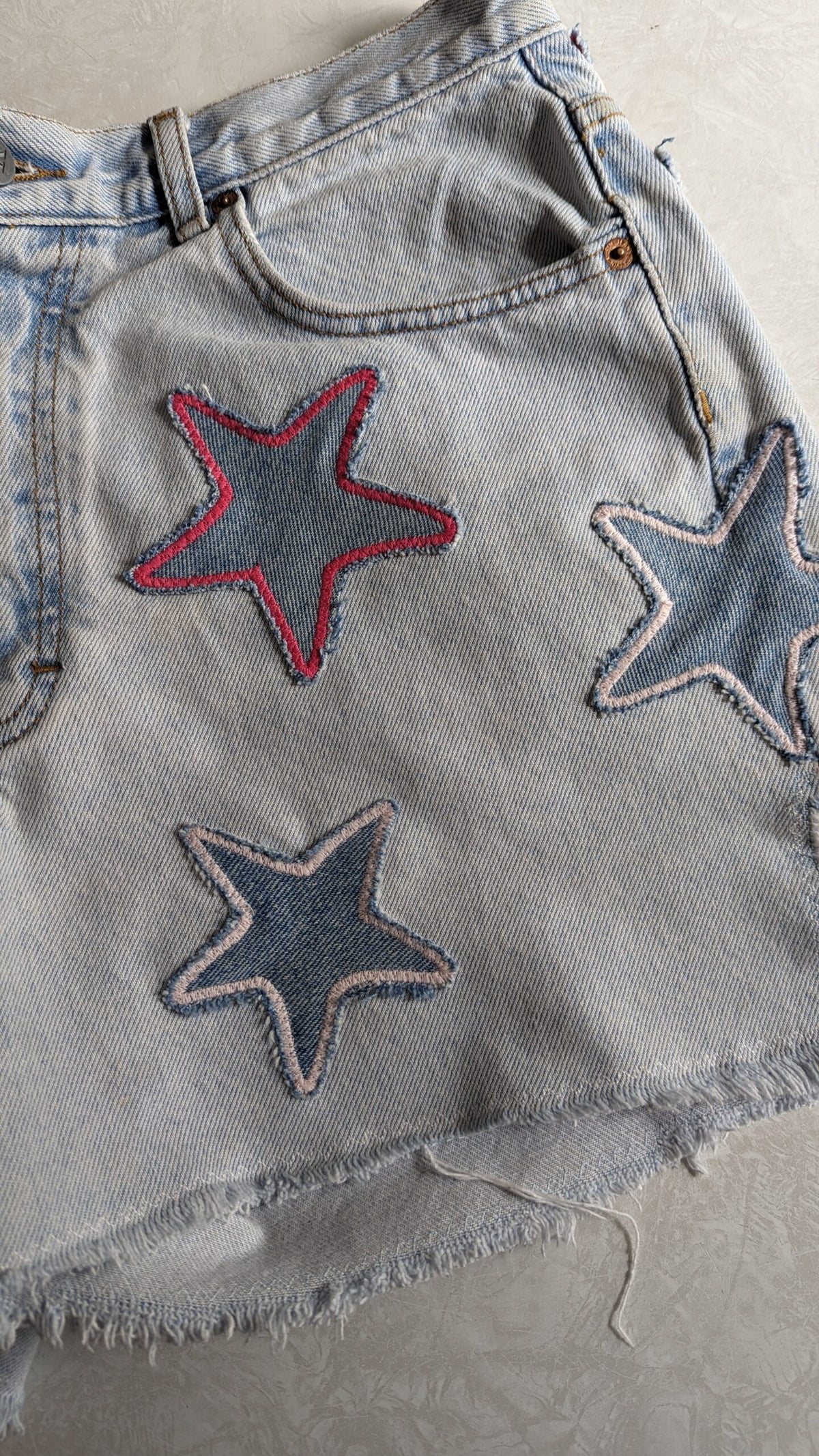 a pair of jean shorts with stars on them.