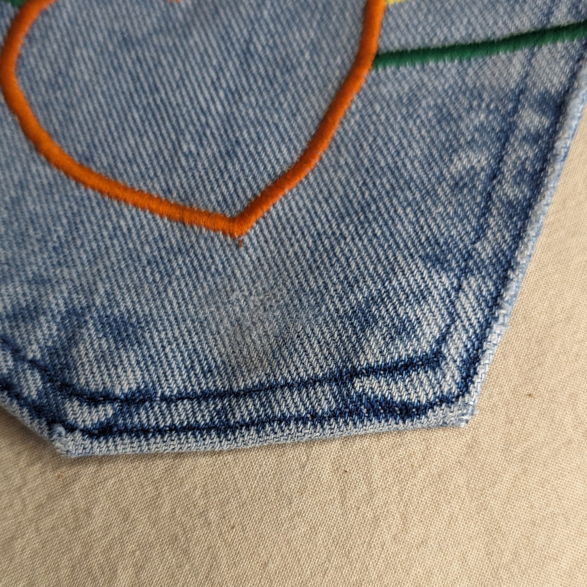 A pocket with a heart embroidered on it.