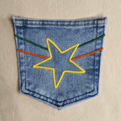 A star embroidered on a denim pocket.