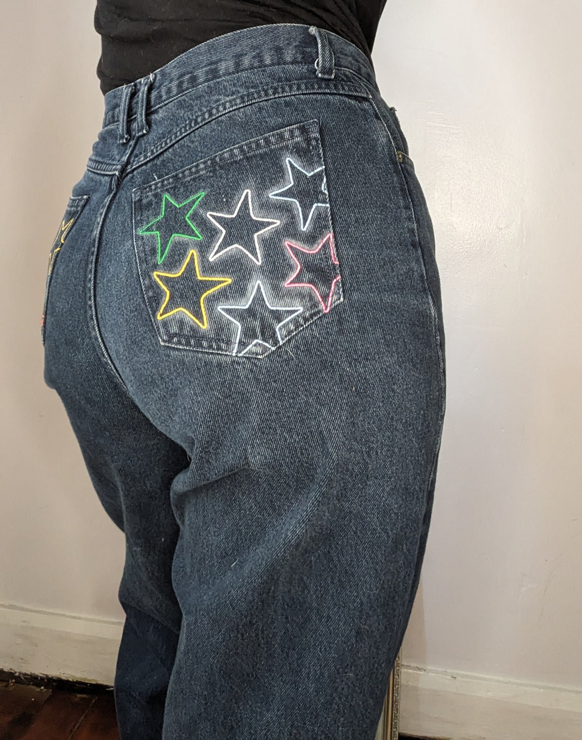 A woman wearing a pair of jeans with stars painted on them.