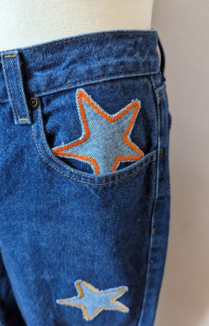 A pair of blue jeans with stars on the pockets.