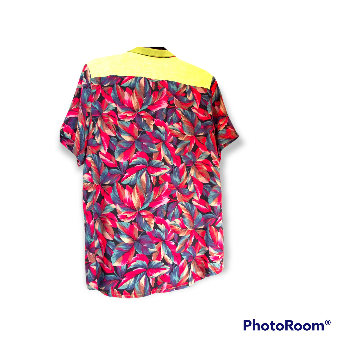 A Men's Floral Shirt hanging on a white wall.