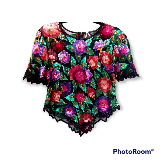 A beaded sequin short sleeve top with flowers on it on a white background.