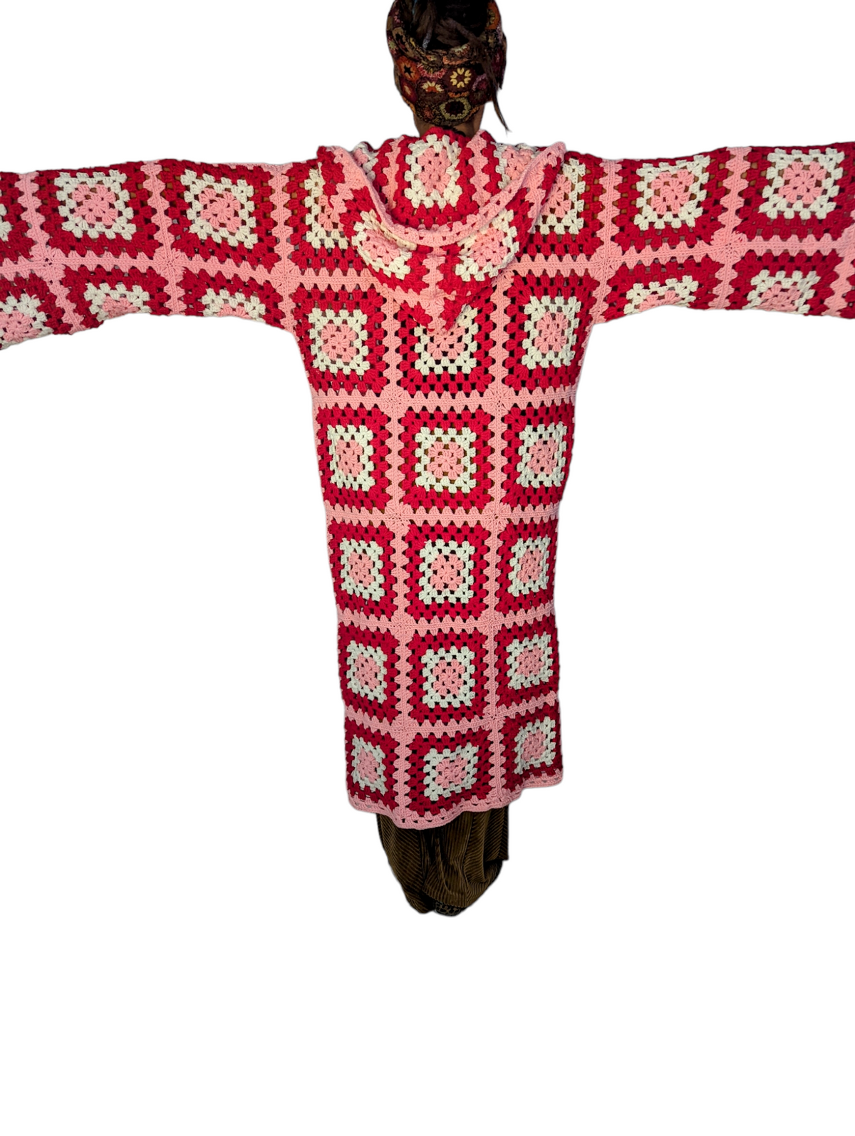 a crocheted figure of a person wearing a red and white sweater.
