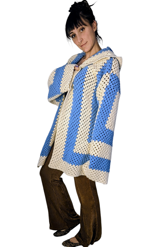 a woman in a blue and white sweater and brown pants.