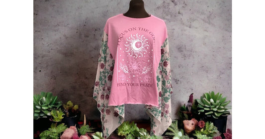 A pink t - shirt on a mannequin with plants.