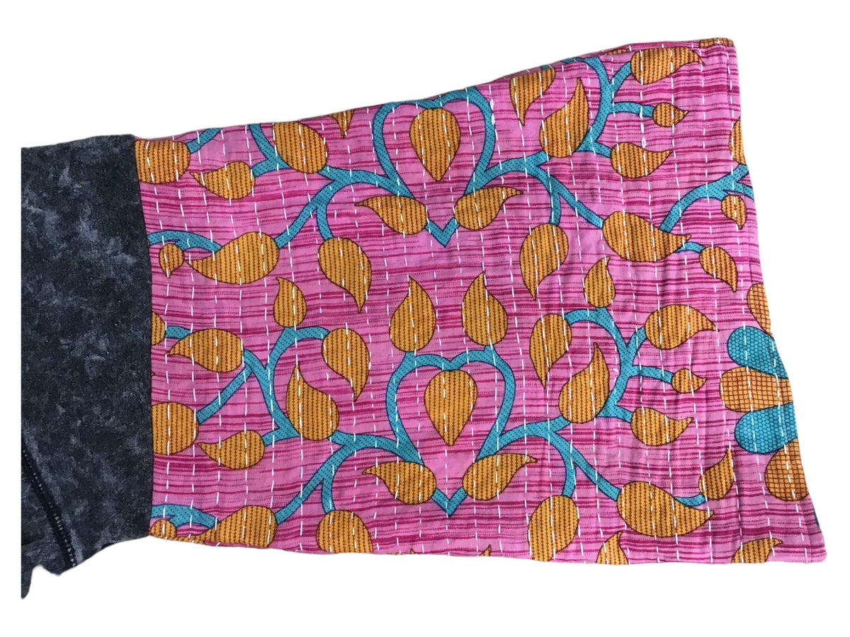 A pink and blue pillow with a floral pattern.