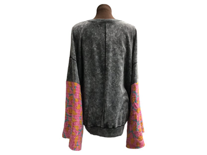A mannequin wearing a black and pink sweater.