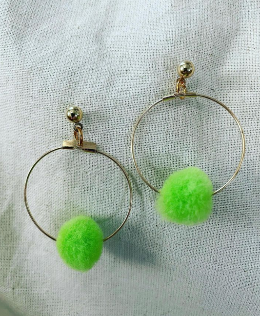 a pair of hoop earrings with green pom poms.