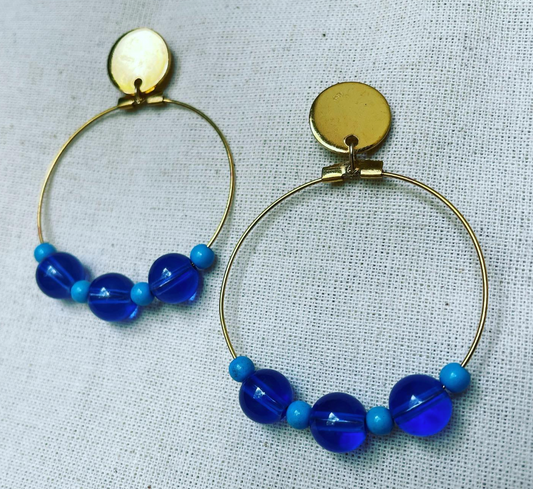 a pair of hoop earrings with blue beads.