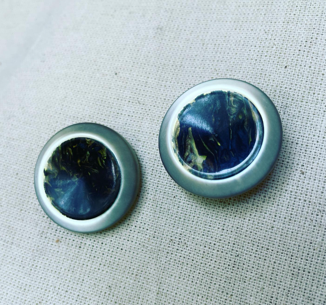 two buttons on a white cloth with a white background.