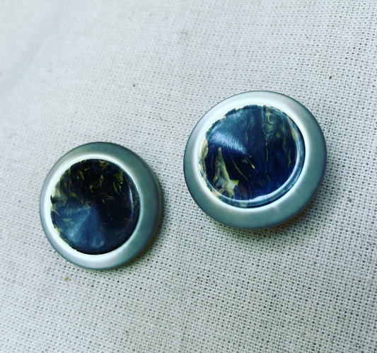 two buttons on a white cloth with a white background.