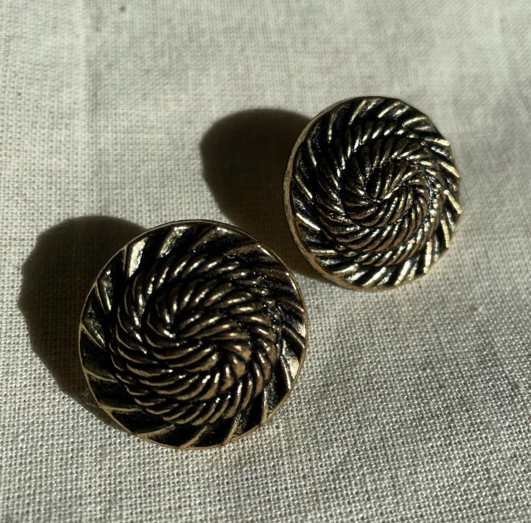 a pair of earrings sitting on top of a table.
