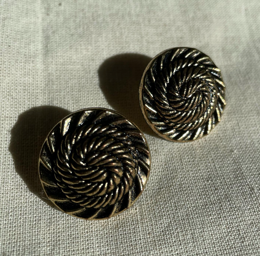 a pair of earrings sitting on top of a table.