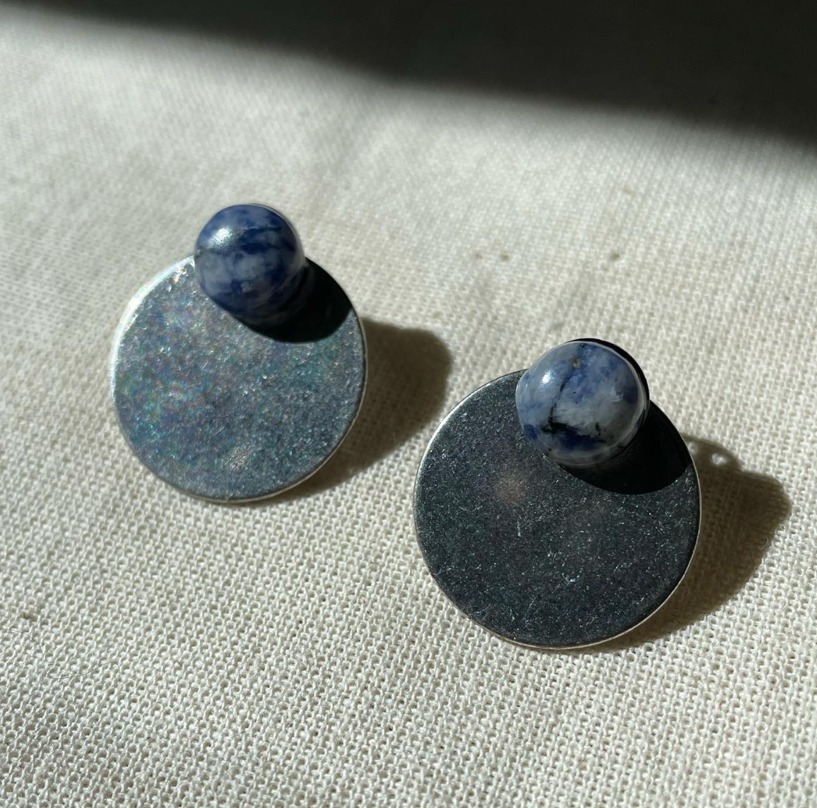 a pair of earrings sitting on top of a table.