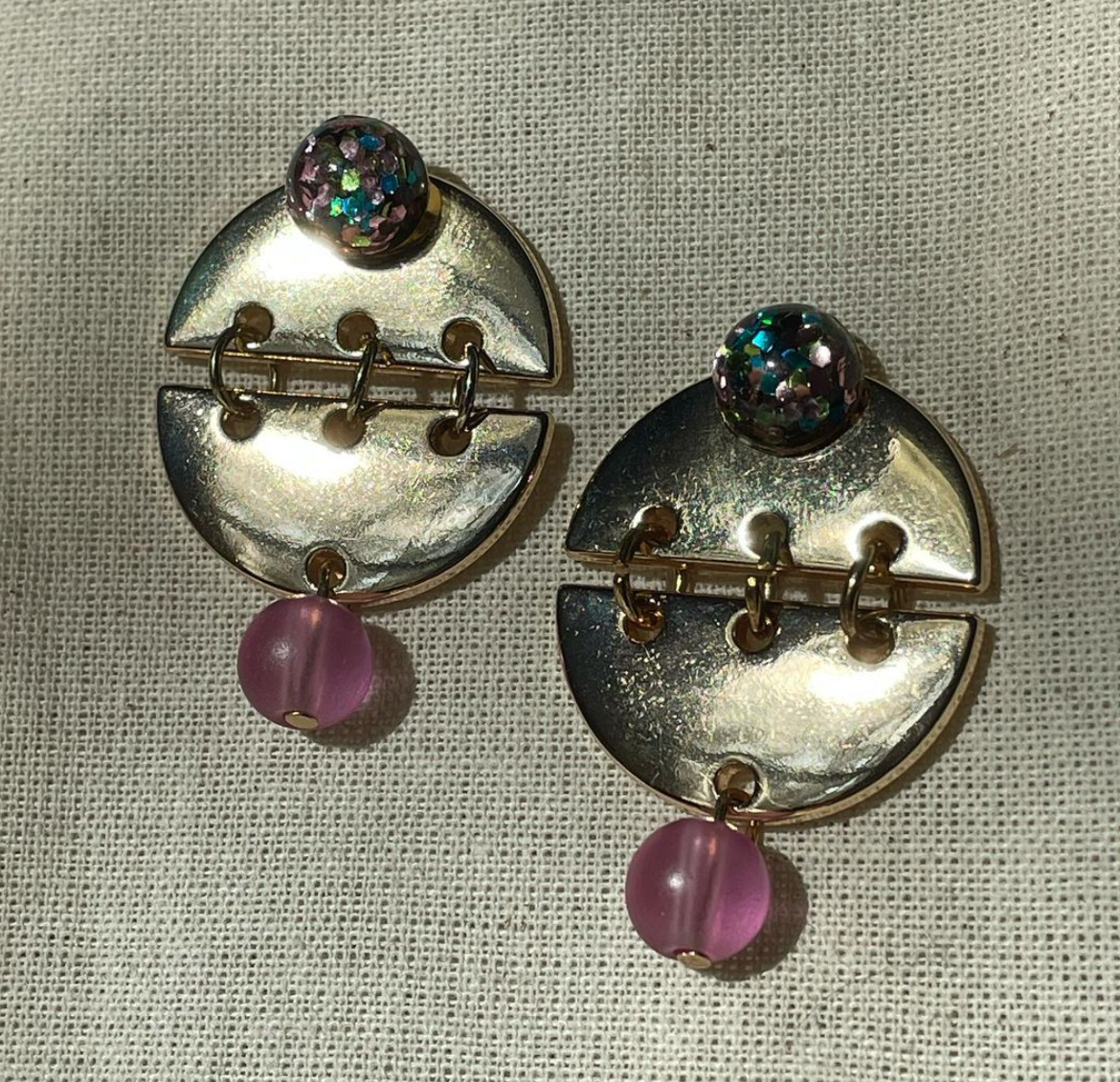a pair of earrings sitting on top of a table.