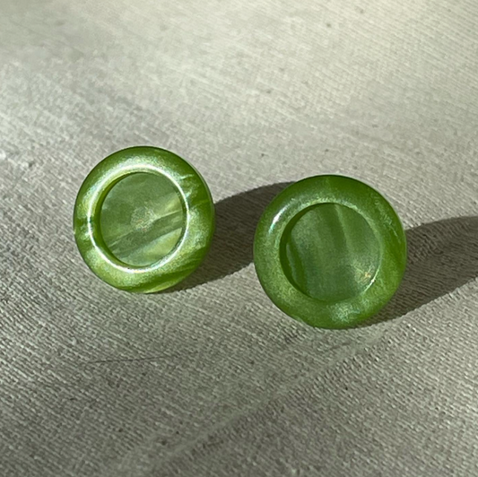 a pair of green buttons sitting on top of a table.