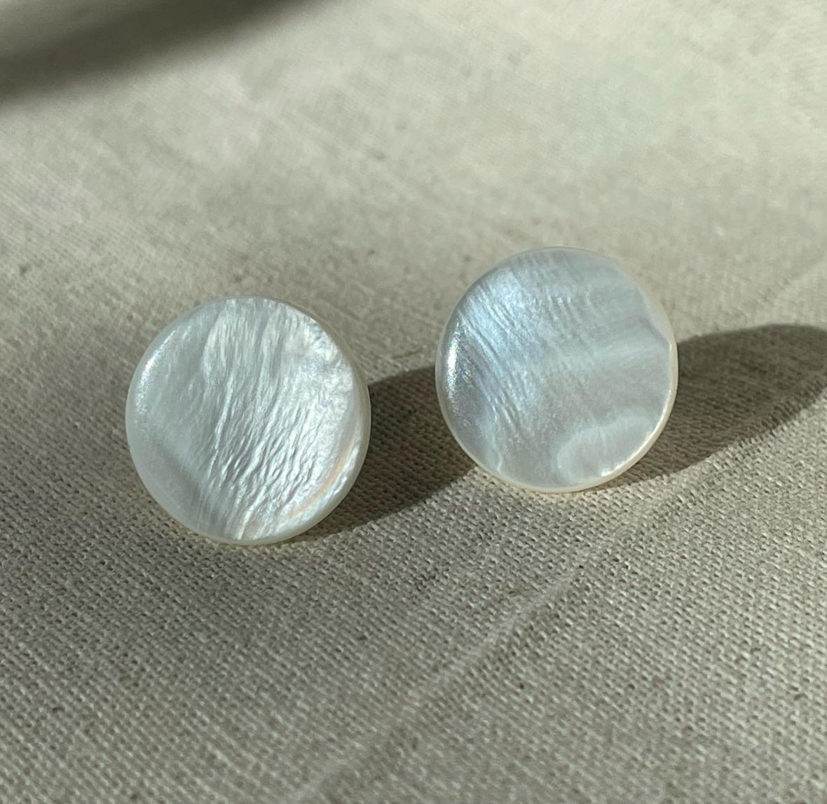a pair of earrings sitting on top of a table.