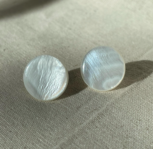 a pair of earrings sitting on top of a table.