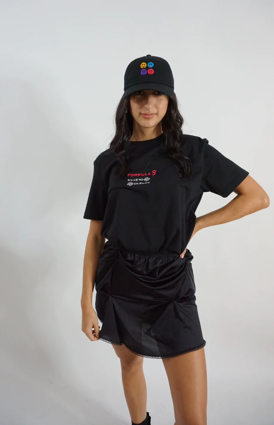 A young woman wearing a BLACK LACE ICING Mini Skirt and black shirt.