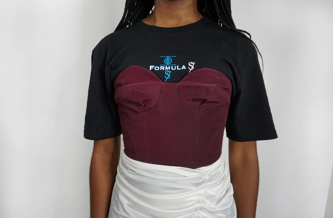A woman wearing a Plum Bustier Strapless Crop Top with a white skirt.
