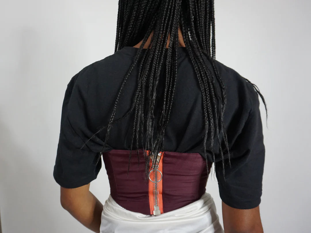 The back of a woman's Plum Bustier Strapless Crop Top with braids.
