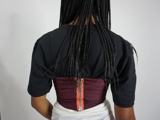 The back of a woman's Plum Bustier Strapless Crop Top with braids.