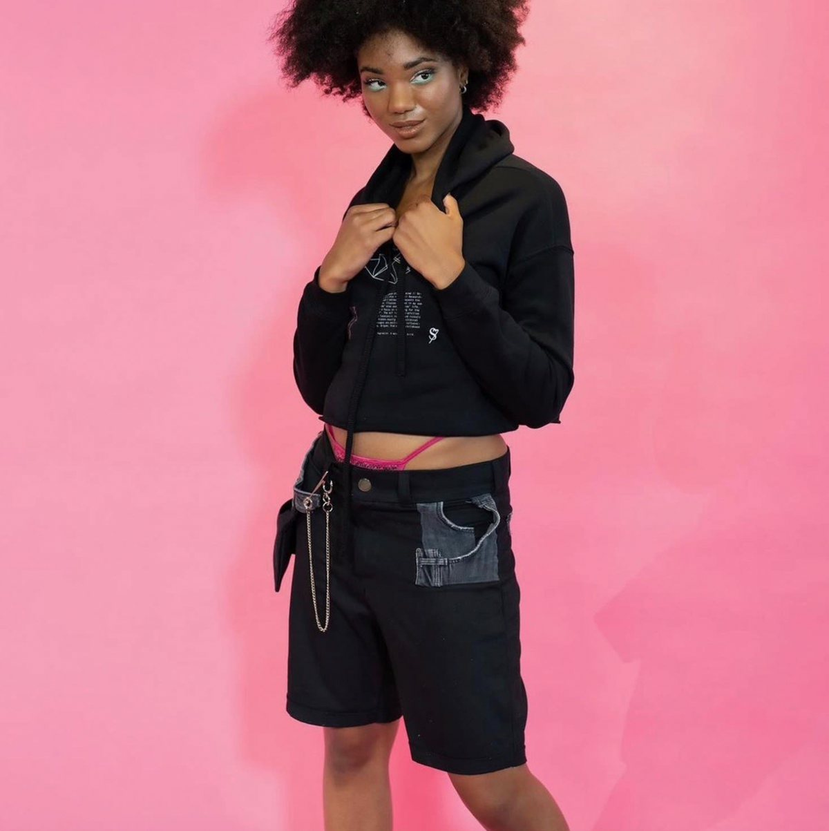 A woman posing for a picture in front of a Bull Denim Up-worked Short background.
