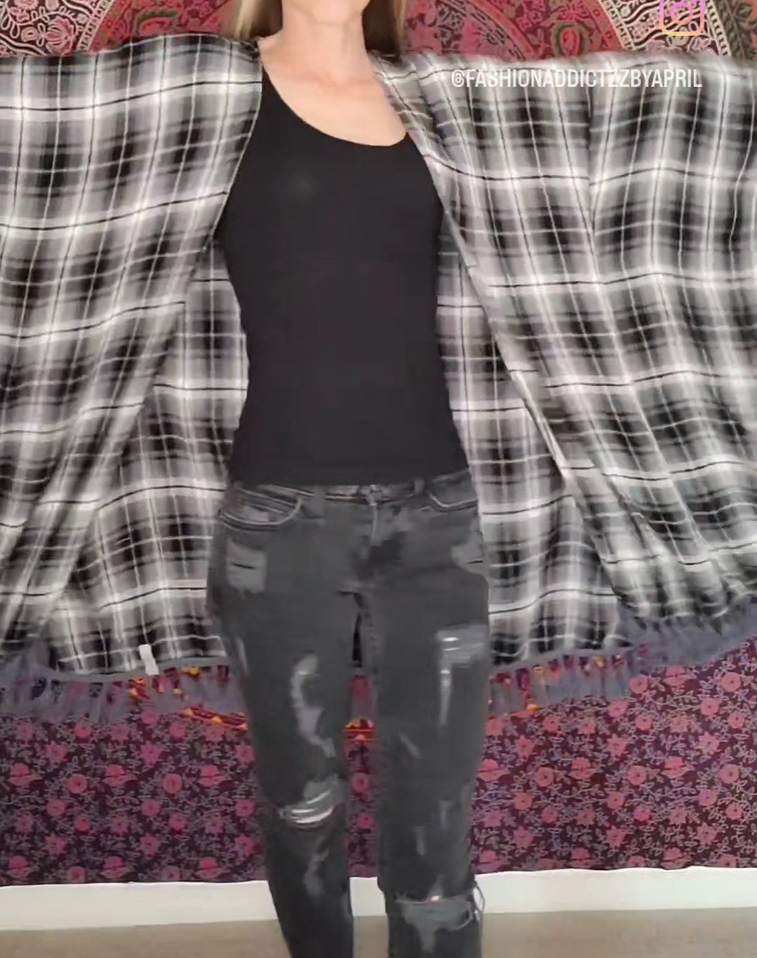 a woman is standing in front of a quilt.
