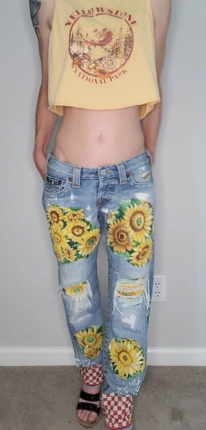 a woman wearing a yellow tank top and jeans with sunflowers on them.