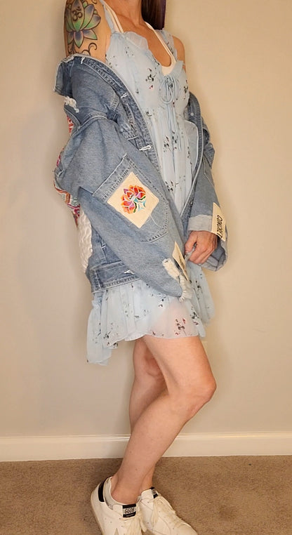 a woman wearing a denim jacket and a dress.