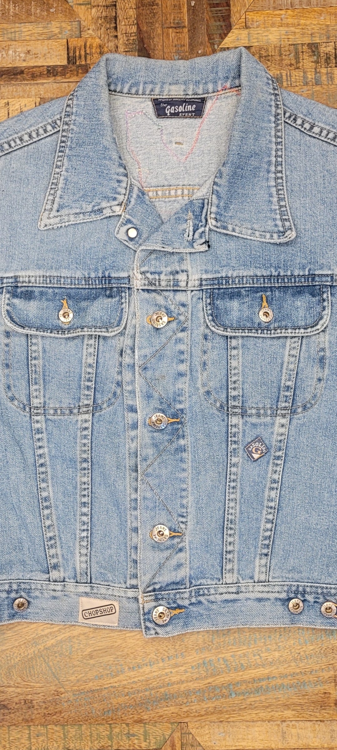 A denim jacket on a wooden surface.
