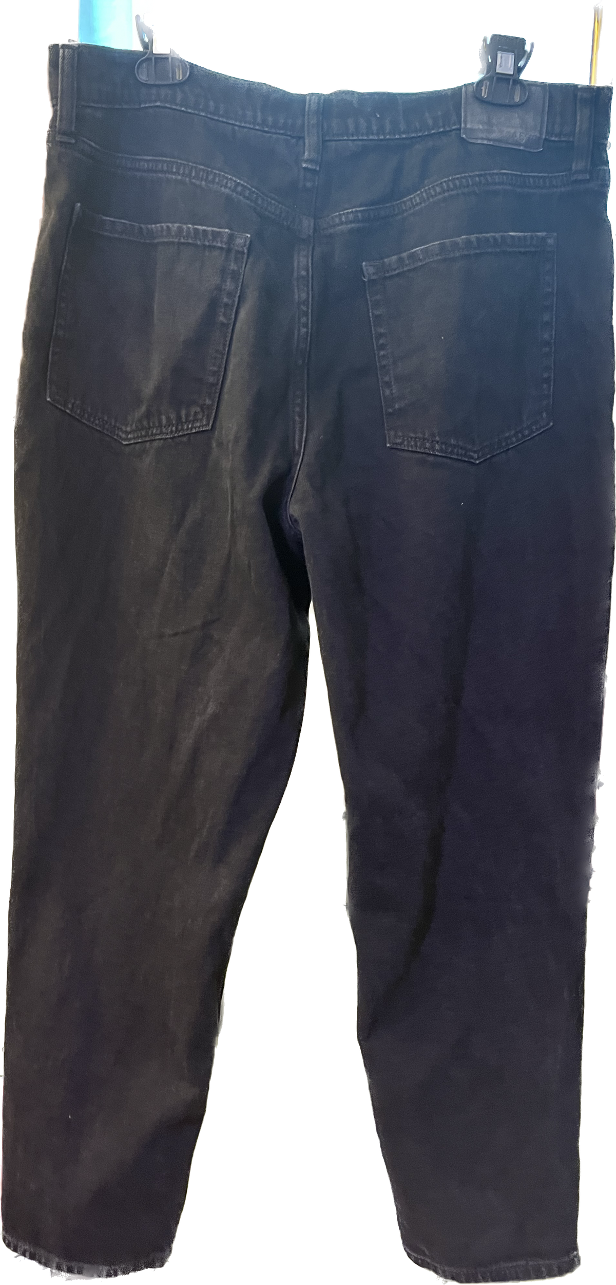 A pair of men's black jean shorts on a hanger.