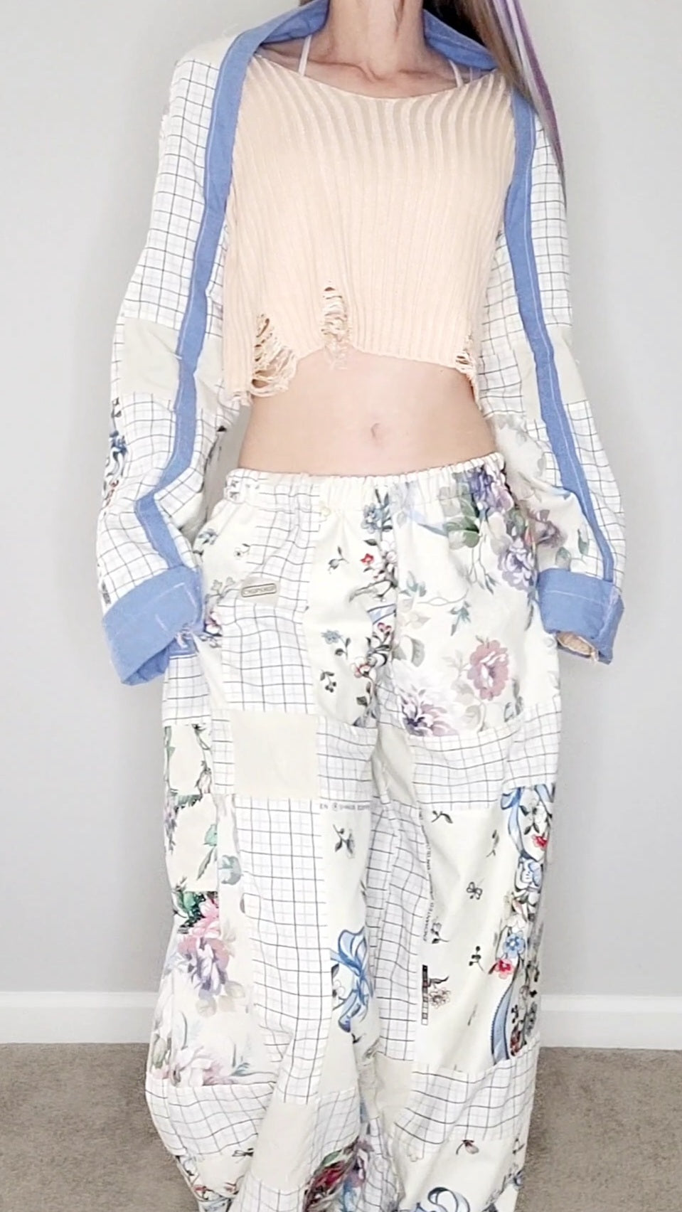 A woman wearing a floral top and pants.