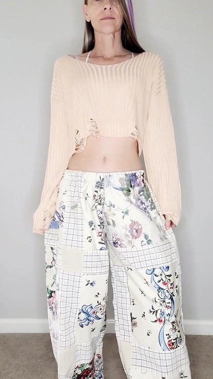 A woman wearing a crop top and floral pants.