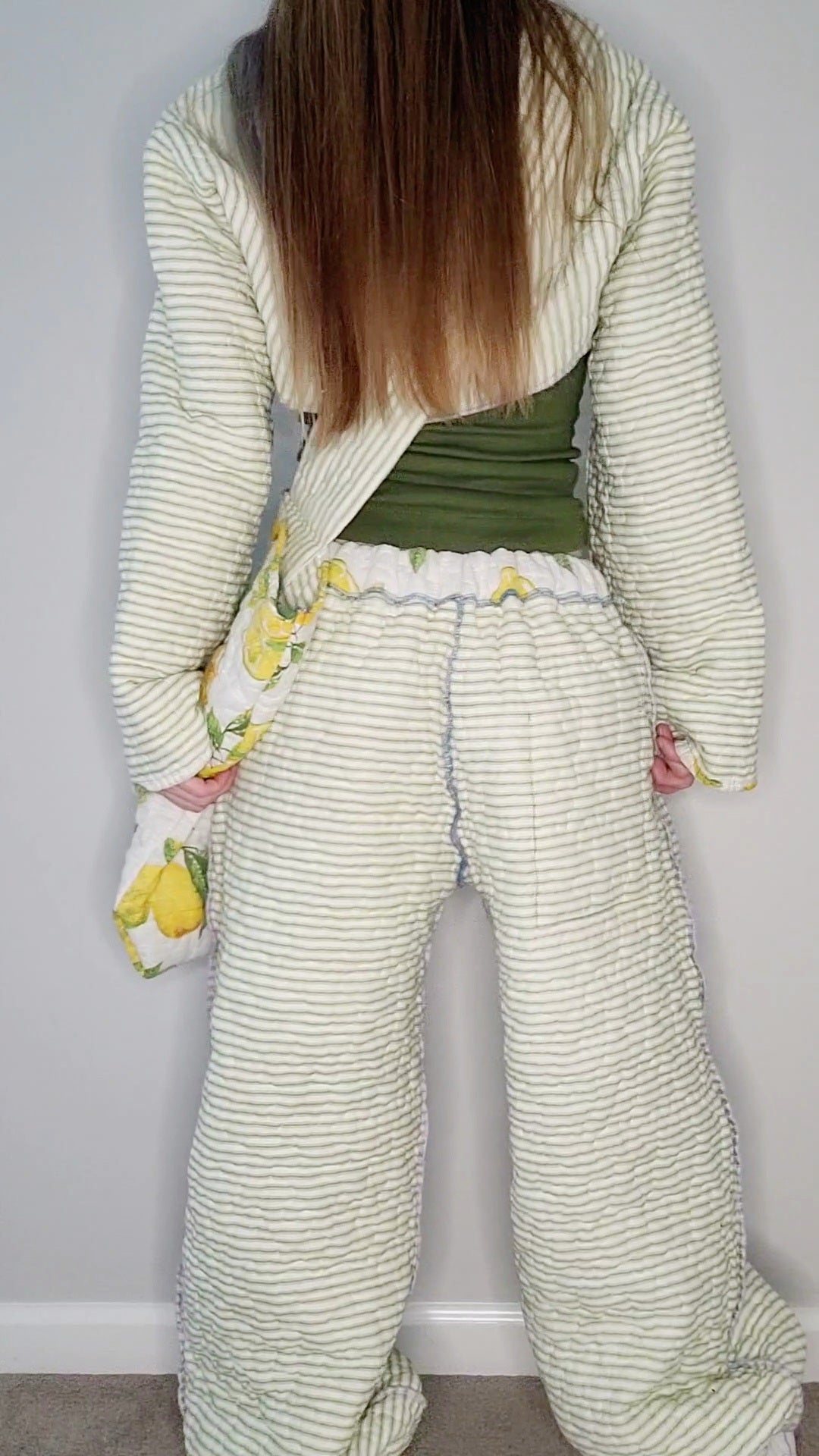 A woman in a green and white striped pajama set.