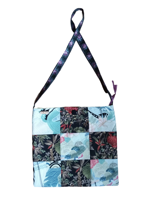 A handbag with a patchwork pattern and a strap.