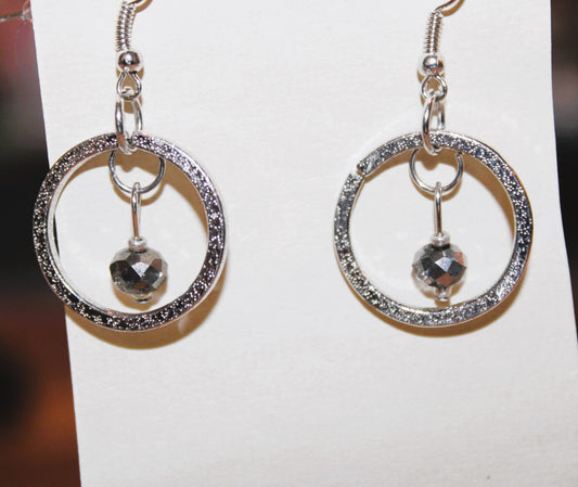 A pair of silver dangle earrings with a black stone.