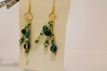 A pair of earrings with green and blue beads.
