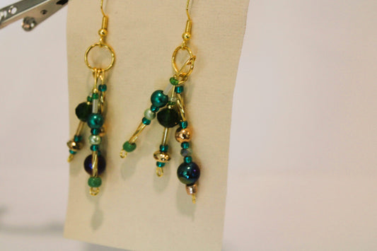 A pair of earrings with green and blue beads.
