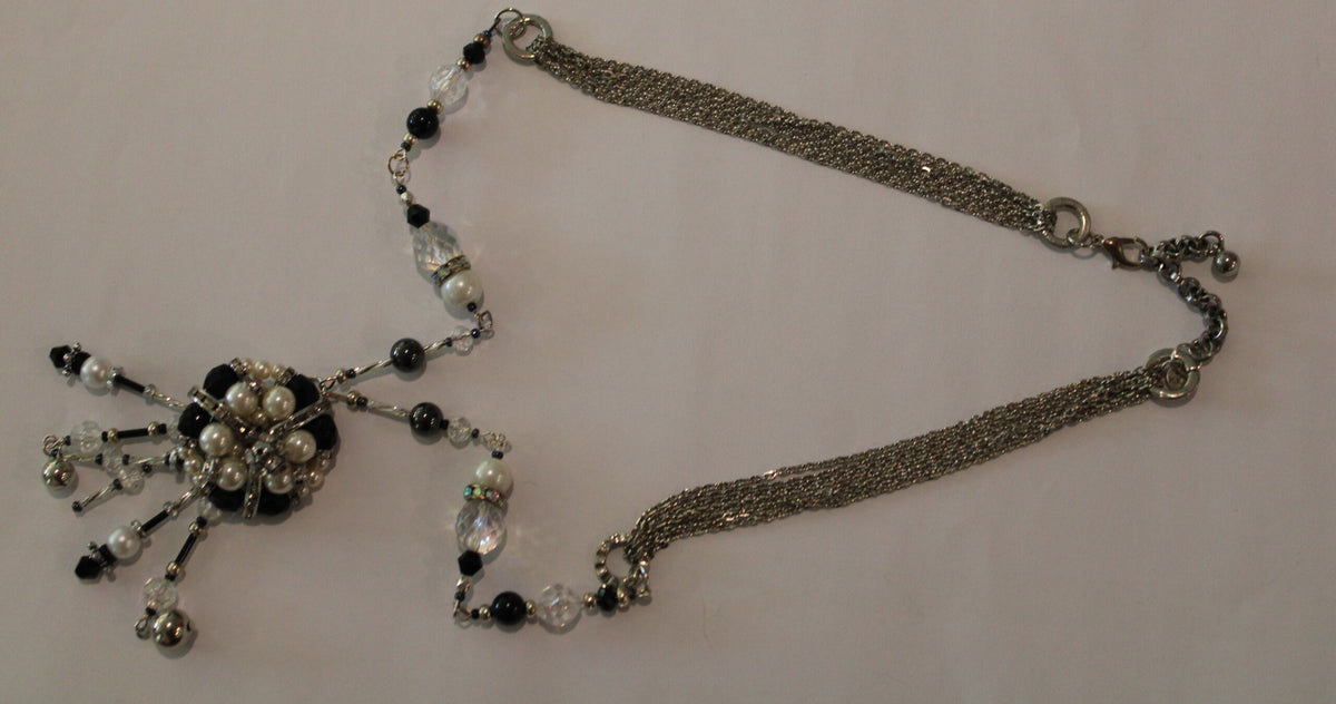 A necklace with black and white beads on it.