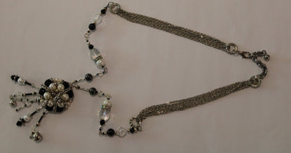 A necklace with black and white beads on it.