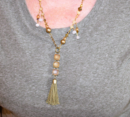 A woman wearing a necklace with a tassel.