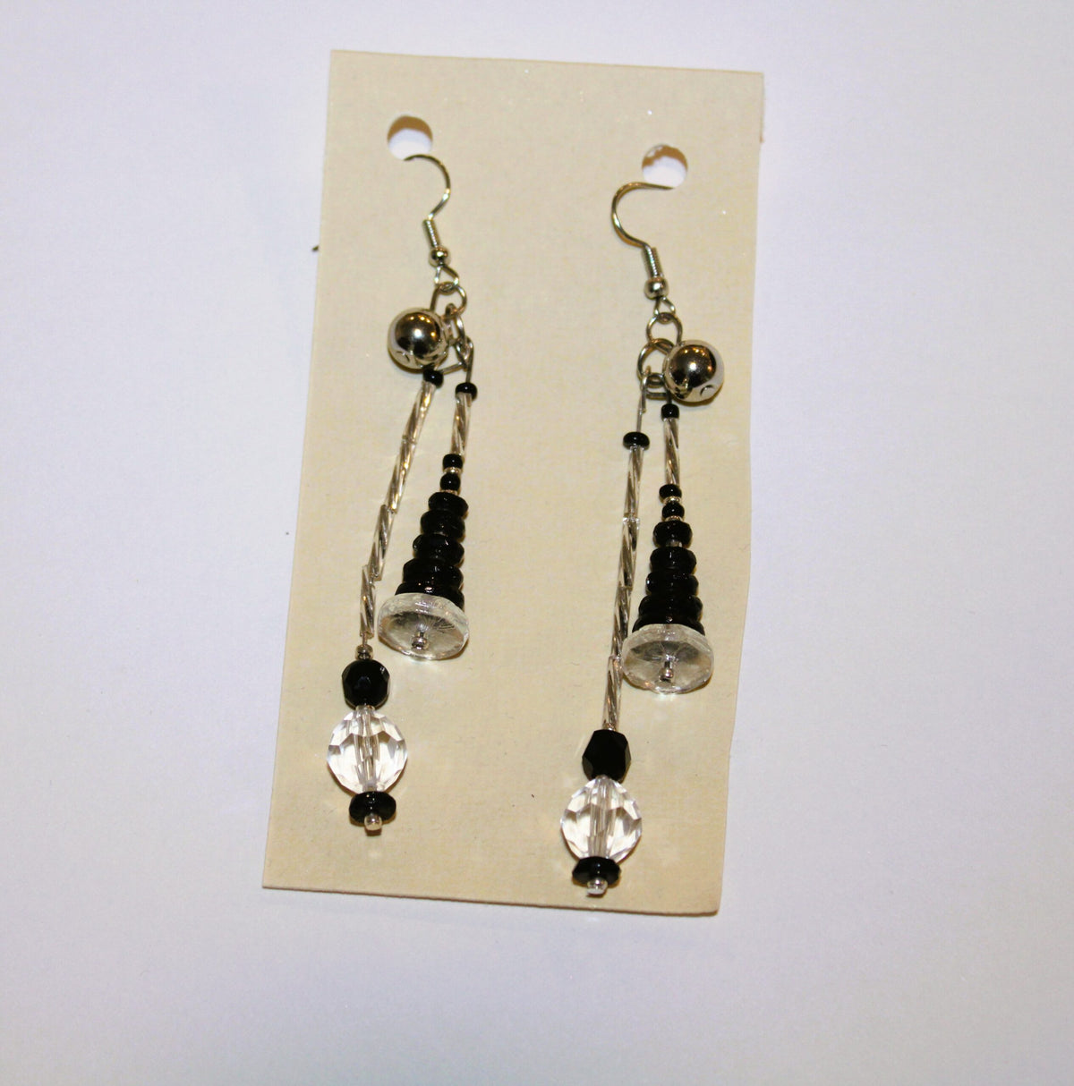 A pair of black and white dangling earrings.
