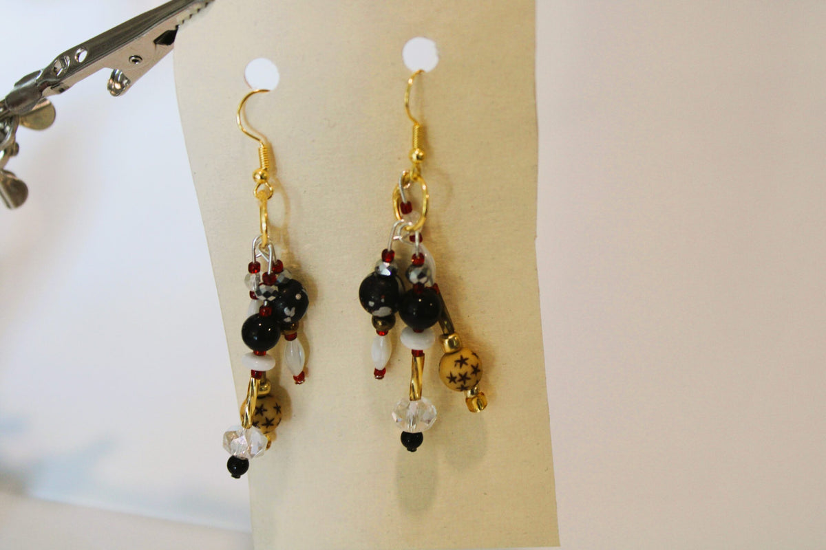 A pair of earrings hanging from a pair of scissors.