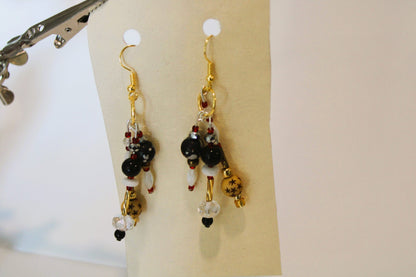 A pair of earrings hanging from a pair of scissors.