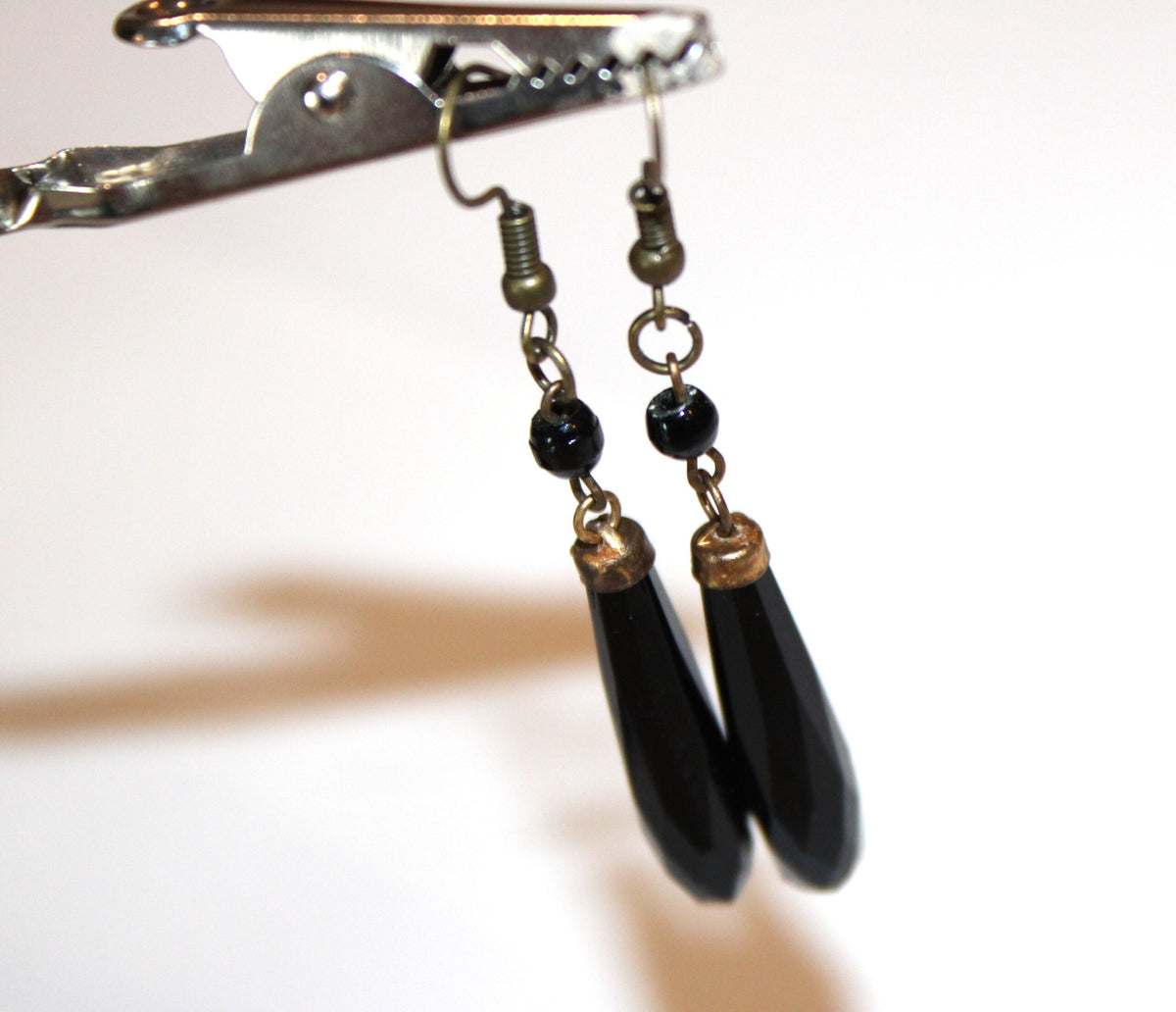 Black jet drop earrings held up to dangle