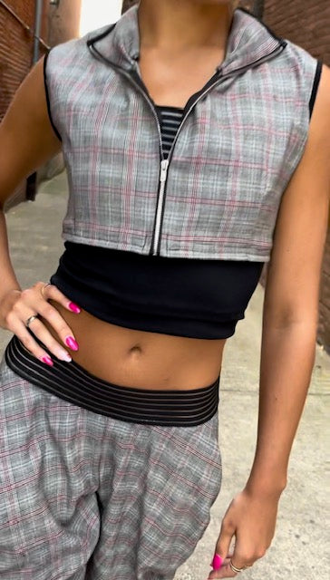 A woman wearing a grey and black plaid top and pants.